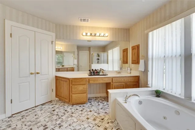 a spacious bathroom with a bathtub sink and mirror