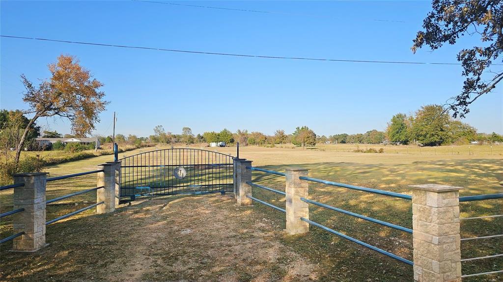 View of yard with a rural view and a gate