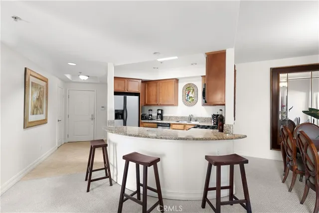 a kitchen with stainless steel appliances kitchen island a table and chairs in it