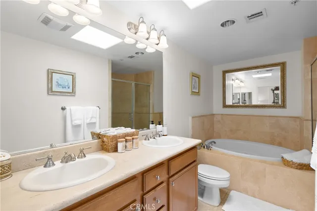 a bathroom with a double vanity sink mirror and bathtub