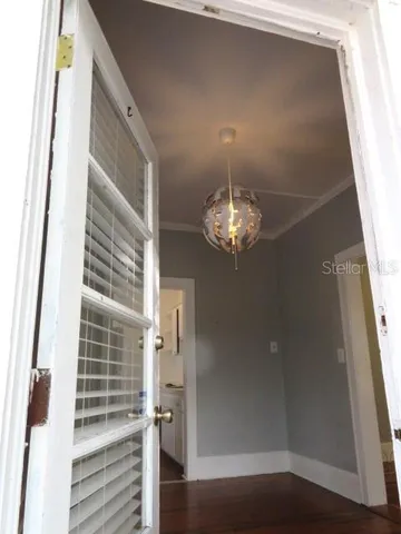 a view of a hallway with wooden floor and staircase