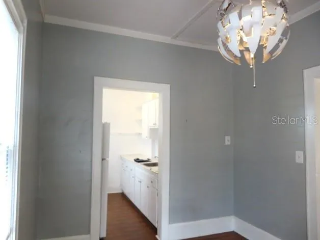 a room with a chandelier fan and a window