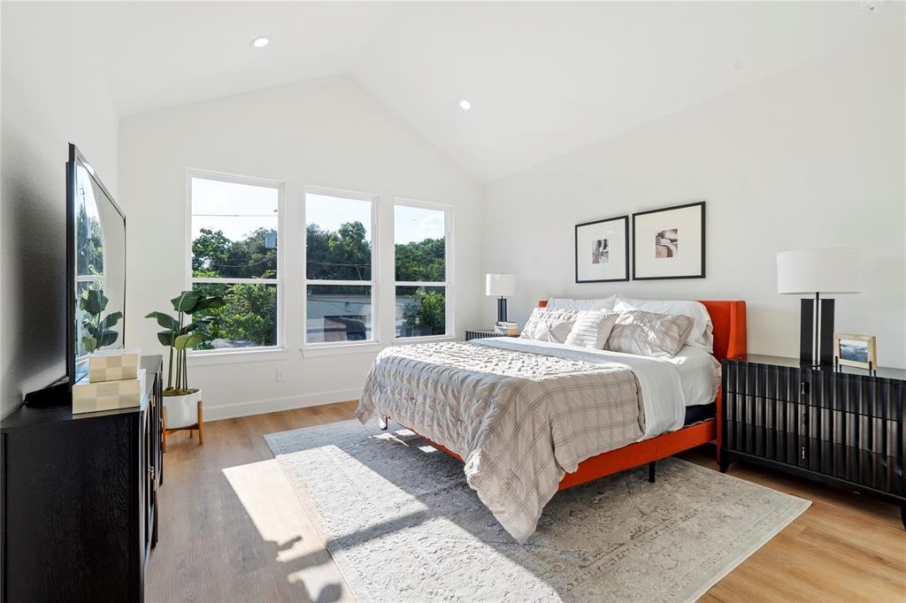 6321 Foster Street Houston, TX 77021 - Photo 10 of 19 Sunlit bedroom with vaulted ceilings, featuring large windows, a cozy bed, and elegant furnishings.