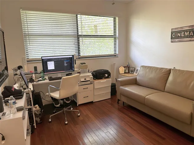 a view of a workspace with furniture and a window