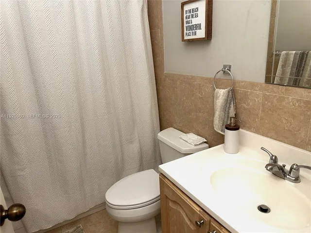 a bathroom with a toilet and a shower curtain