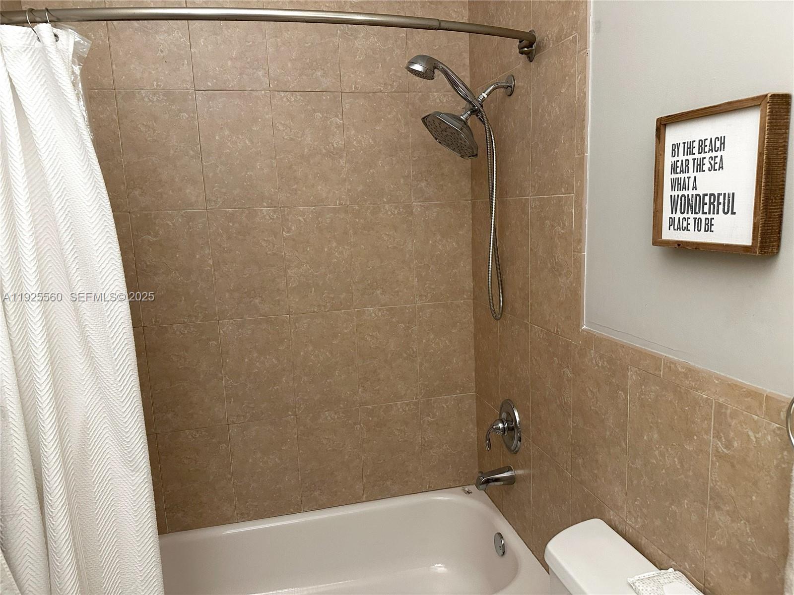 55 Ocean Ln Drive, Unit 4020 Key Biscayne, FL 33149 - Photo 29 of 57 a bathroom with a toilet and a shower curtain