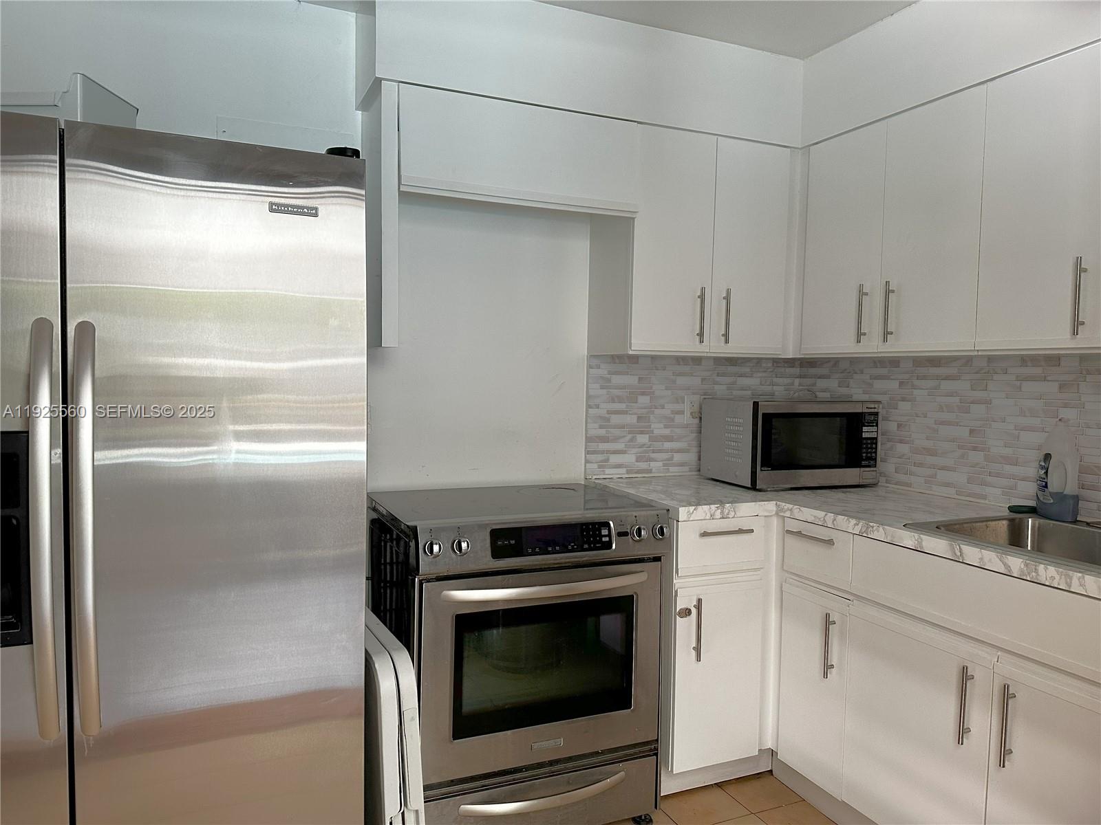 55 Ocean Ln Drive, Unit 4020 Key Biscayne, FL 33149 - Photo 39 of 57 a kitchen with white cabinets and stainless steel appliances