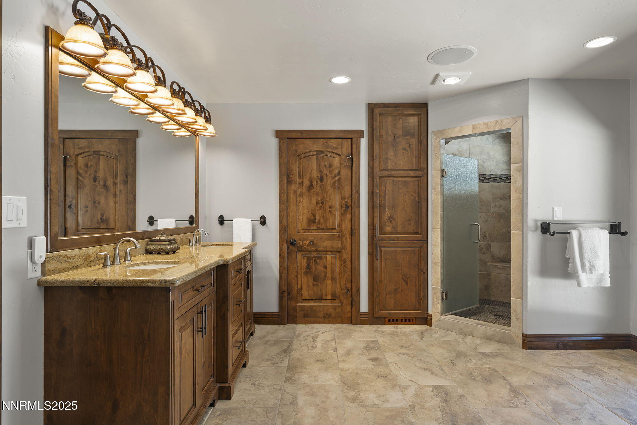 3405 Lone Tree Lane Reno, NV 89511 - Photo 36 of 80 a bathroom with a granite countertop sink a large mirror and a shower
