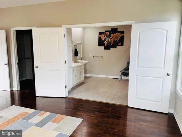 a view of a bedroom with wooden floor and cabinet