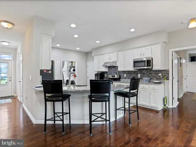 a kitchen with stainless steel appliances granite countertop a refrigerator and a stove top oven