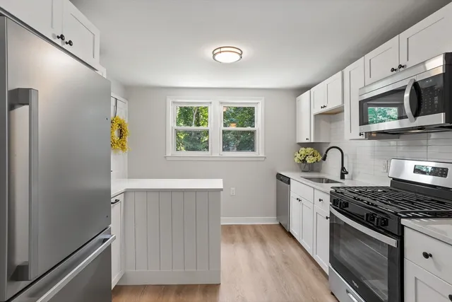 a kitchen with stainless steel appliances a stove a sink and a microwave