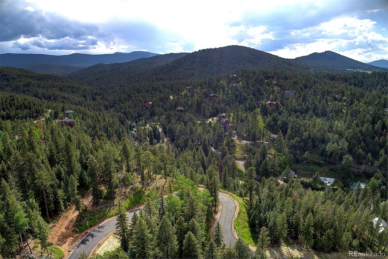 6874 Lynx Lair Road Evergreen, CO 80439 - Photo 15 of 15 a view of a houses with a lush green hillside