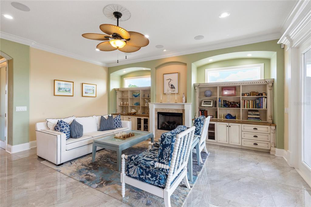 3523 West Shell Point Road Ruskin, FL 33570 - Photo 12 of 89 a living room with furniture a fireplace and a chandelier