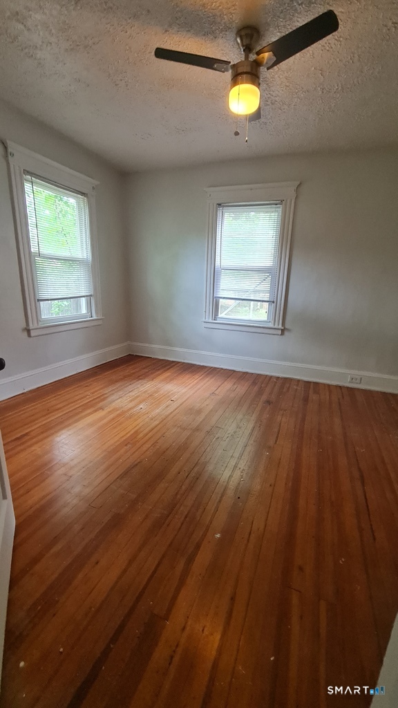 64-66 Ridge Street Manchester, CT 06040 - Photo 3 of 21 wooden floor in an empty room with a window