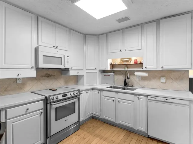 a kitchen with cabinets appliances and a sink