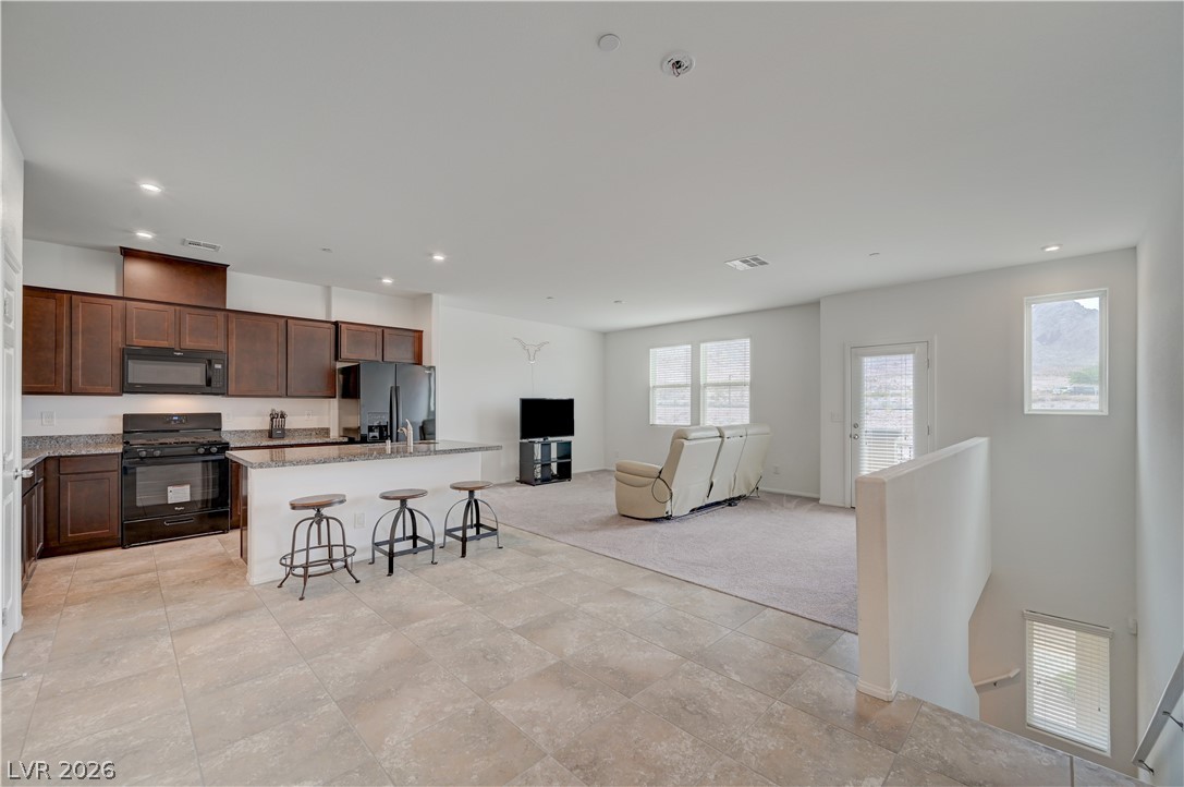 1287 Raritan Place Henderson, NV 89002 - Photo 13 of 21 An open-concept living area seamlessly connects a well-appointed kitchen to a comfortable lounge space.