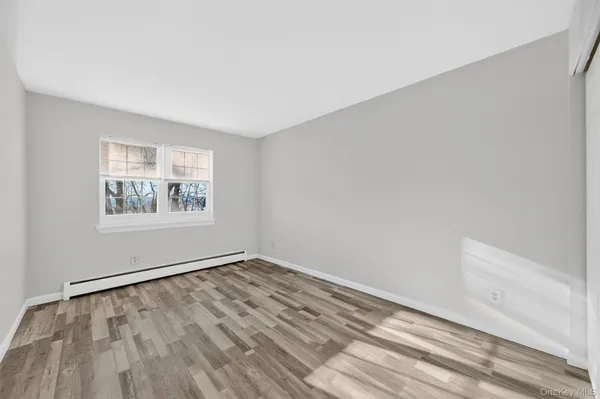 a view of an empty room with wooden floor