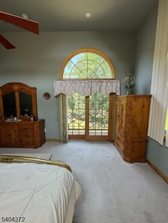a bed sitting in a spacious bedroom next to a window