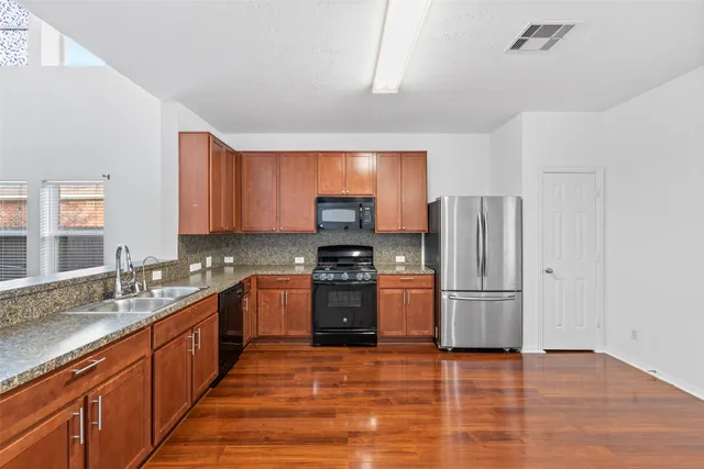 a kitchen with stainless steel appliances granite countertop a refrigerator stove and sink