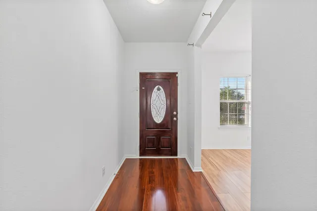 a view of a room with wooden floor and entryway