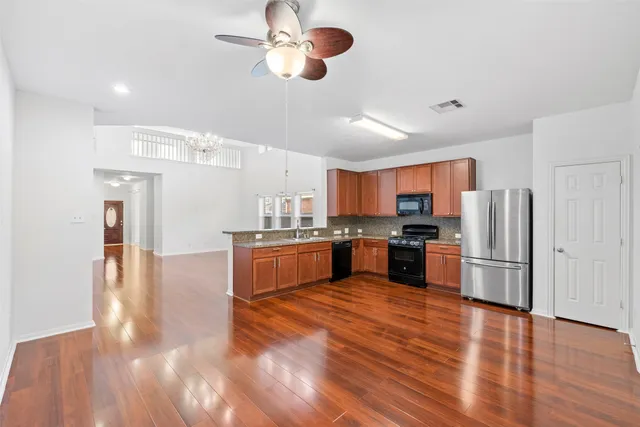 a large kitchen with stainless steel appliances a refrigerator and a stove top oven