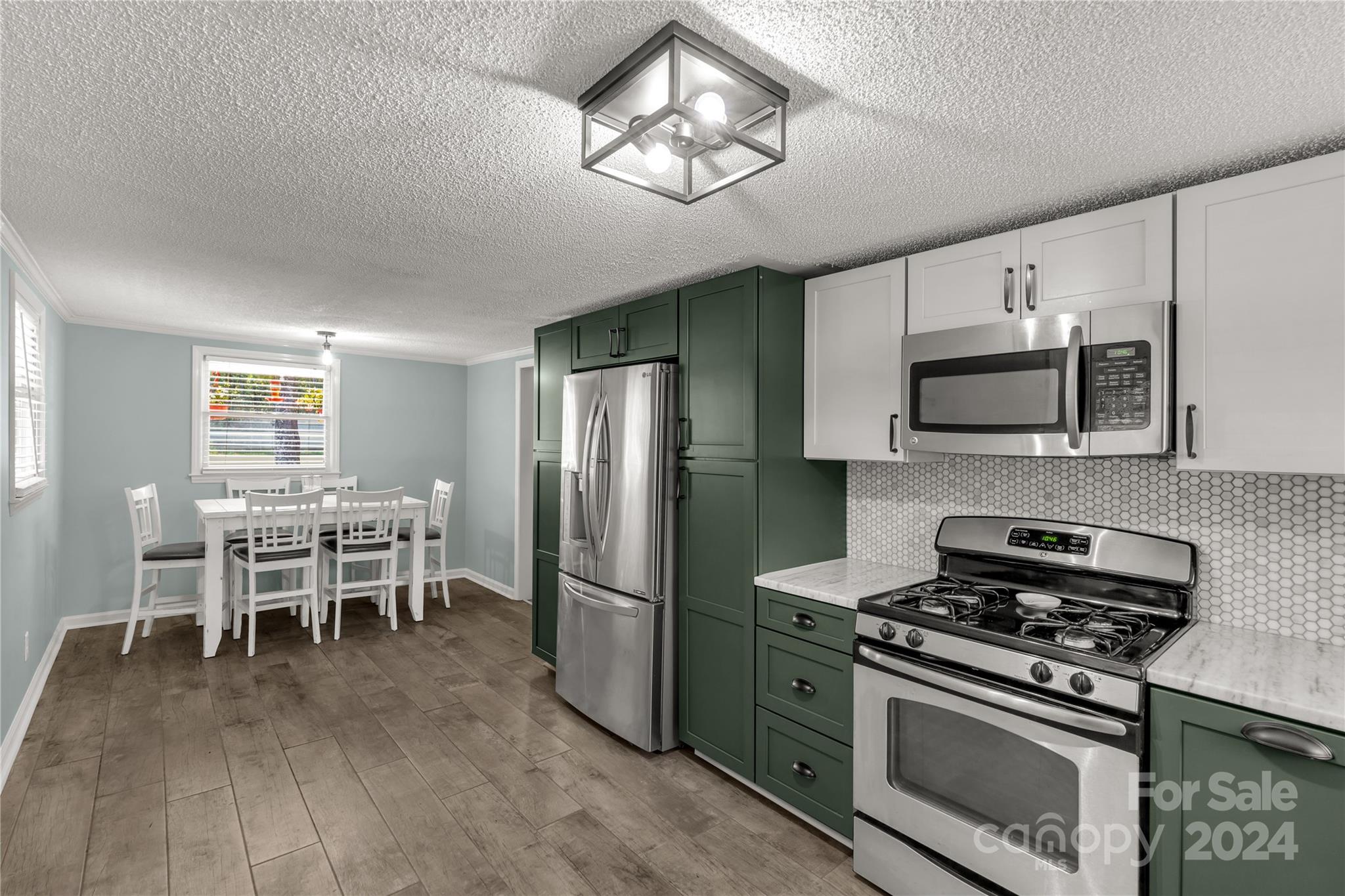 3593 Taxahaw Road Lancaster, SC 29720 - Photo 7 of 23 a kitchen with stainless steel appliances a stove a microwave a dining table and chairs