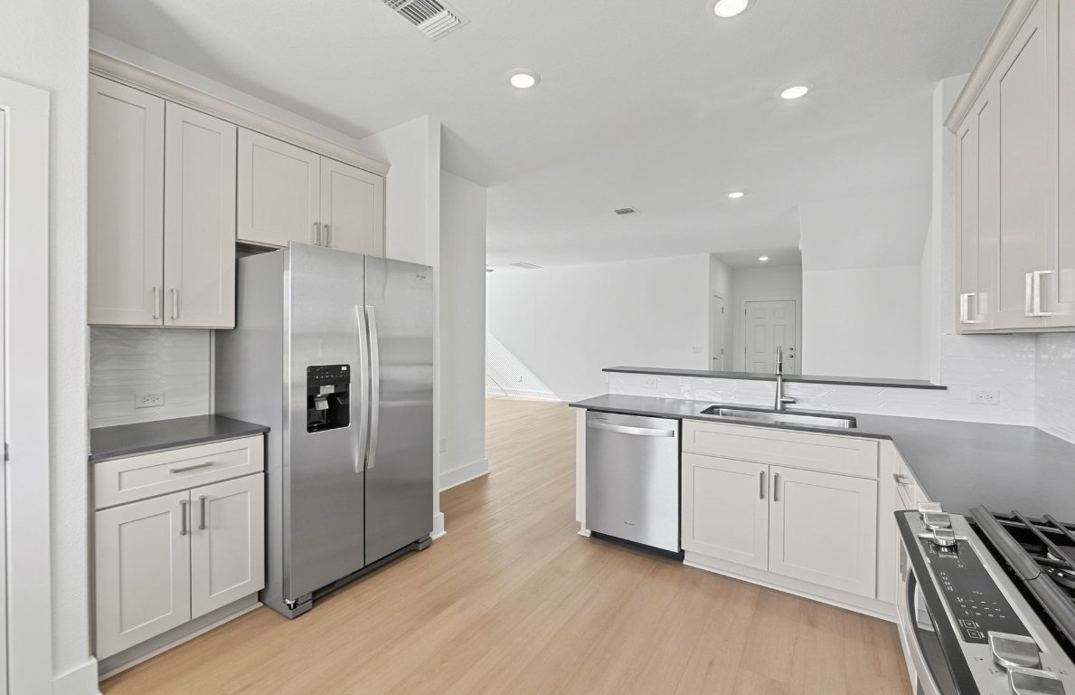 494 Tailwind Drive Kyle, TX 78640 - Photo 12 of 34 a kitchen with stainless steel appliances a refrigerator sink and cabinets