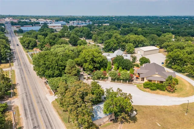 an aerial view of a house with a yard and lake view