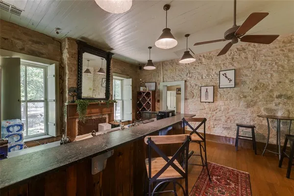 a kitchen with stainless steel appliances kitchen island granite countertop a table chairs and a refrigerator