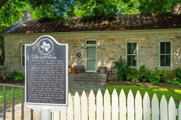 a view of brick house with a wooden fence