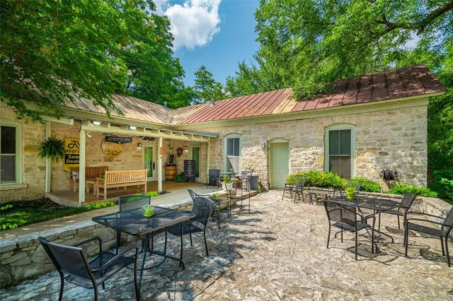a view of a patio with table and chairs under an umbrella