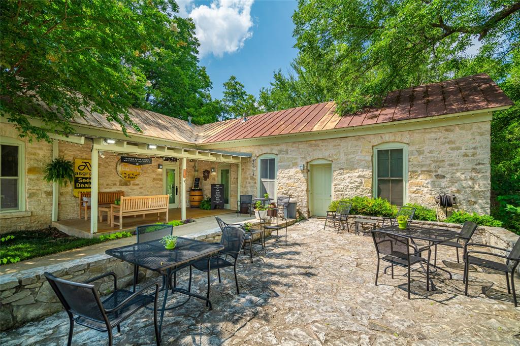 802 South Austin Street Comanche, TX 76442 - Photo 5 of 20 a view of a patio with table and chairs under an umbrella