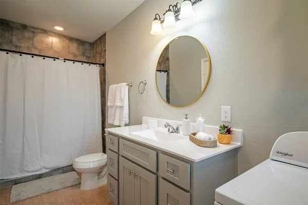 a bathroom with a sink mirror vanity and toilet