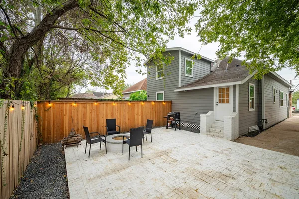 a backyard of a house with barbeque oven table and chairs