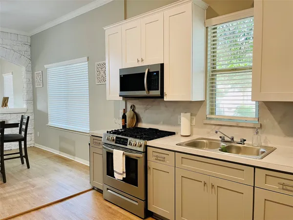 a kitchen with stainless steel appliances white cabinets and a stove top oven