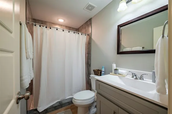 a bathroom with a granite countertop sink toilet and shower