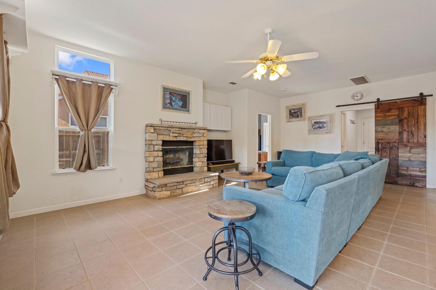 2730 Explorer Way Turlock, CA 95382 - Photo 22 of 64 a living room with furniture a fireplace and a flat screen tv