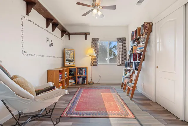 a view of a workspace with furniture and a ceiling fan