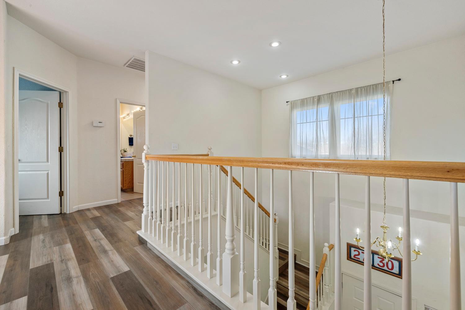 2730 Explorer Way Turlock, CA 95382 - Photo 43 of 64 a view of a hallway with wooden floor