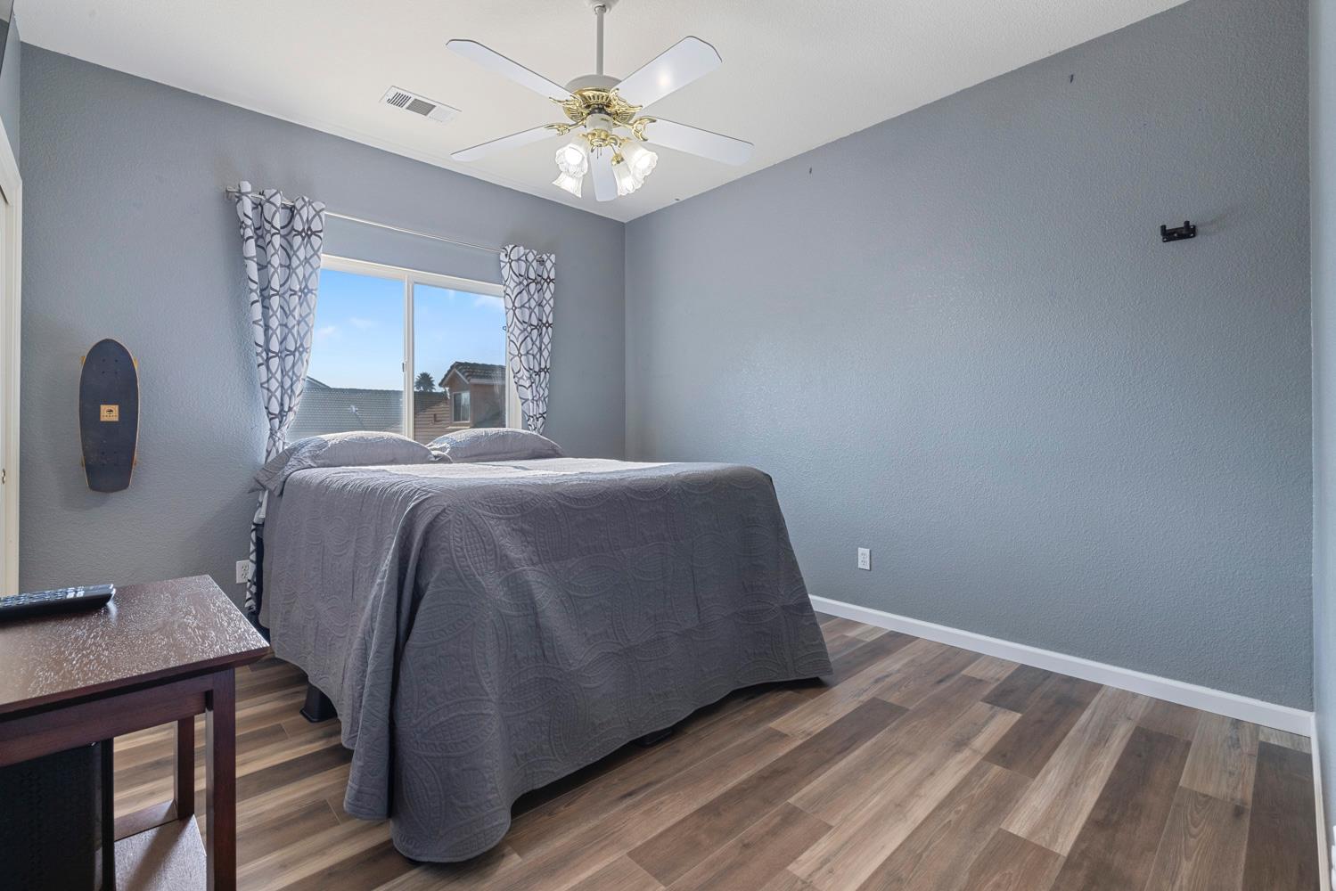 2730 Explorer Way Turlock, CA 95382 - Photo 45 of 64 a bedroom with a bed and a chandelier