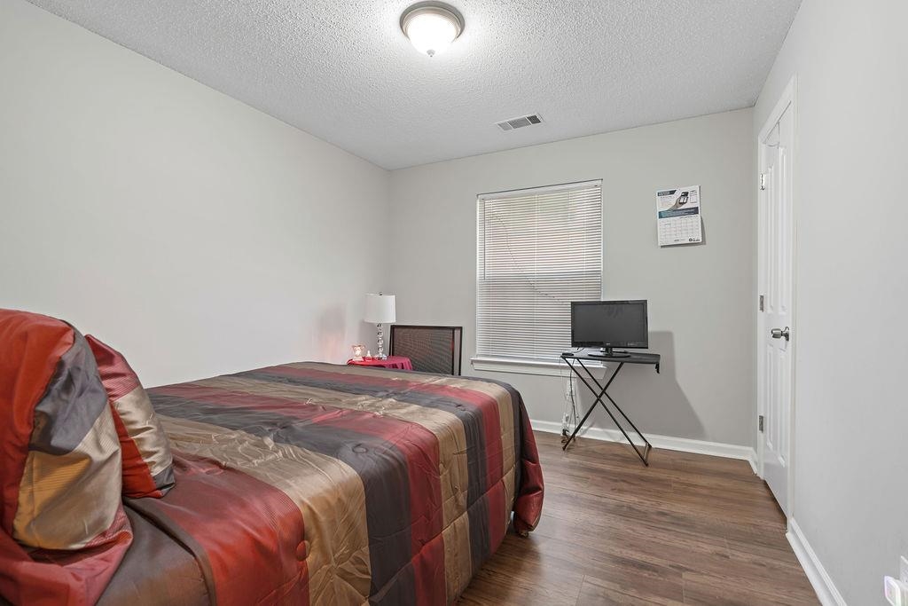 5340 Shady Ridge Cove Memphis, TN 38141 - Photo 13 of 22 Bedroom featuring dark wood-style floors and a textured ceiling