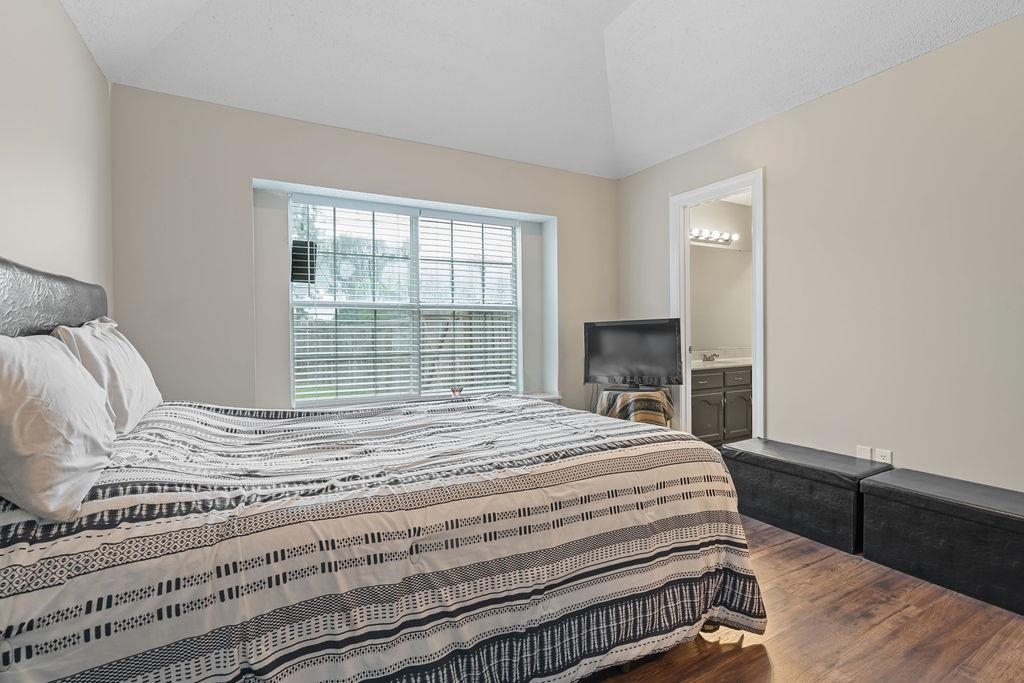 5340 Shady Ridge Cove Memphis, TN 38141 - Photo 19 of 22 Bedroom with dark wood-type flooring, connected bathroom, and vaulted ceiling