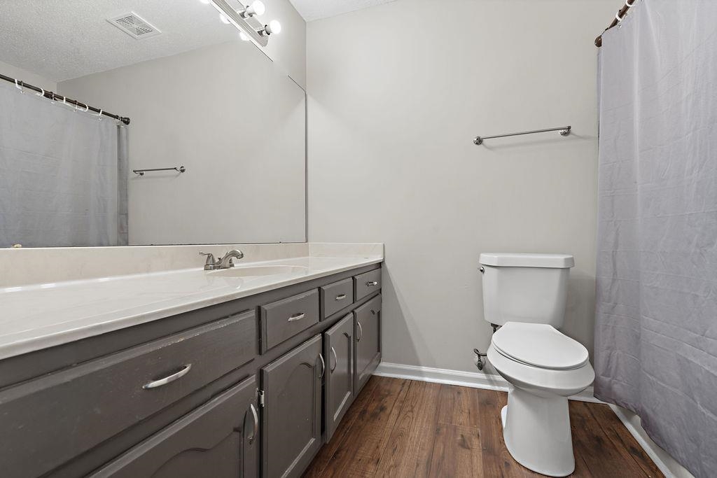 5340 Shady Ridge Cove Memphis, TN 38141 - Photo 20 of 22 Full bathroom with dark wood finished floors, vanity, curtained shower, and a textured ceiling