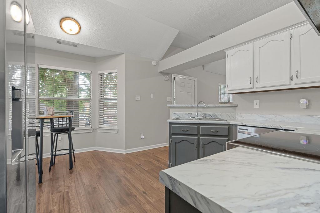 5340 Shady Ridge Cove Memphis, TN 38141 - Photo 9 of 22 Kitchen with light countertops, a textured ceiling, dark wood-style flooring, a peninsula, and gray cabinets