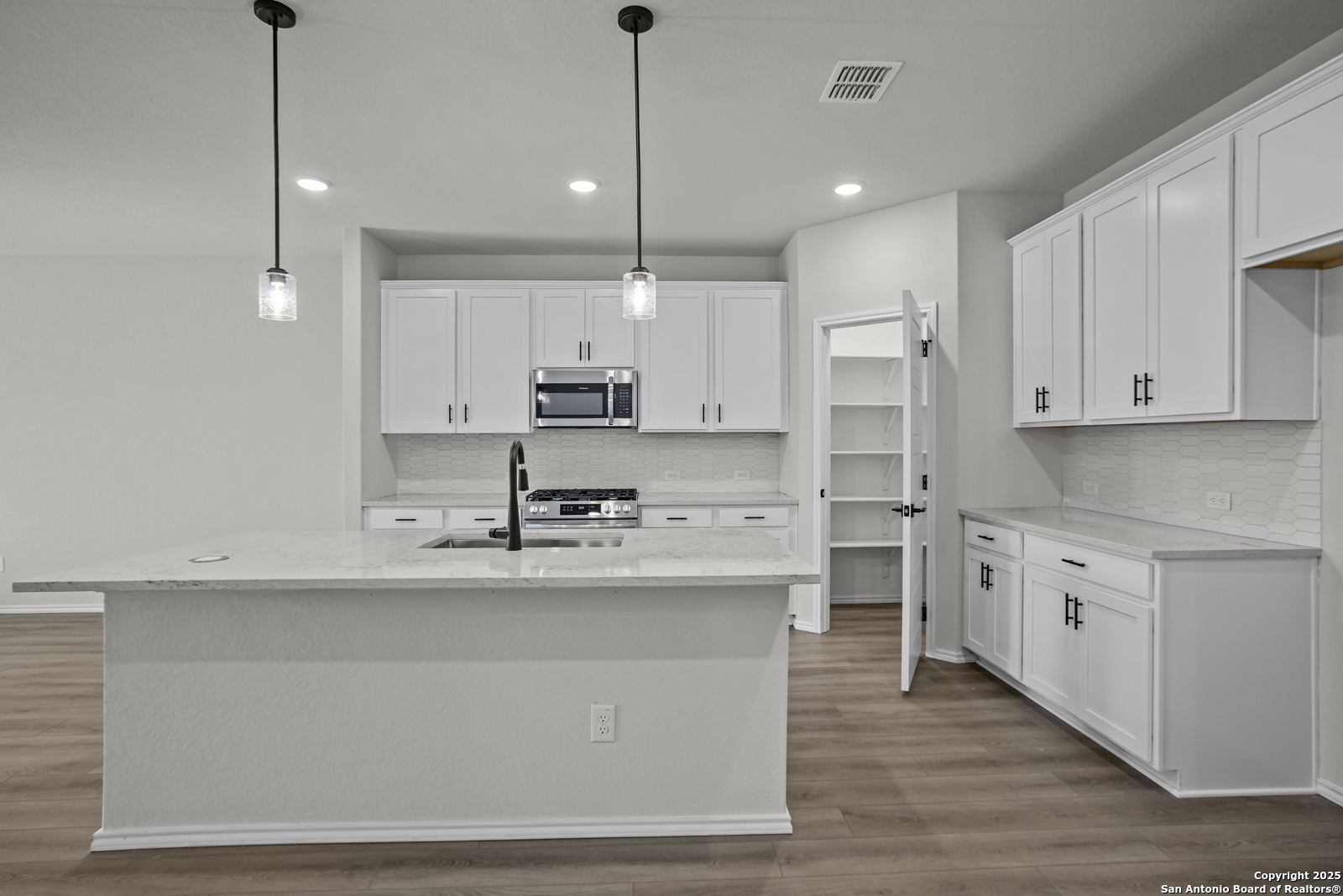 7420 Cremorne Converse, TX 78109 - Photo 9 of 40 a kitchen with kitchen island white cabinets stainless steel appliances and sink