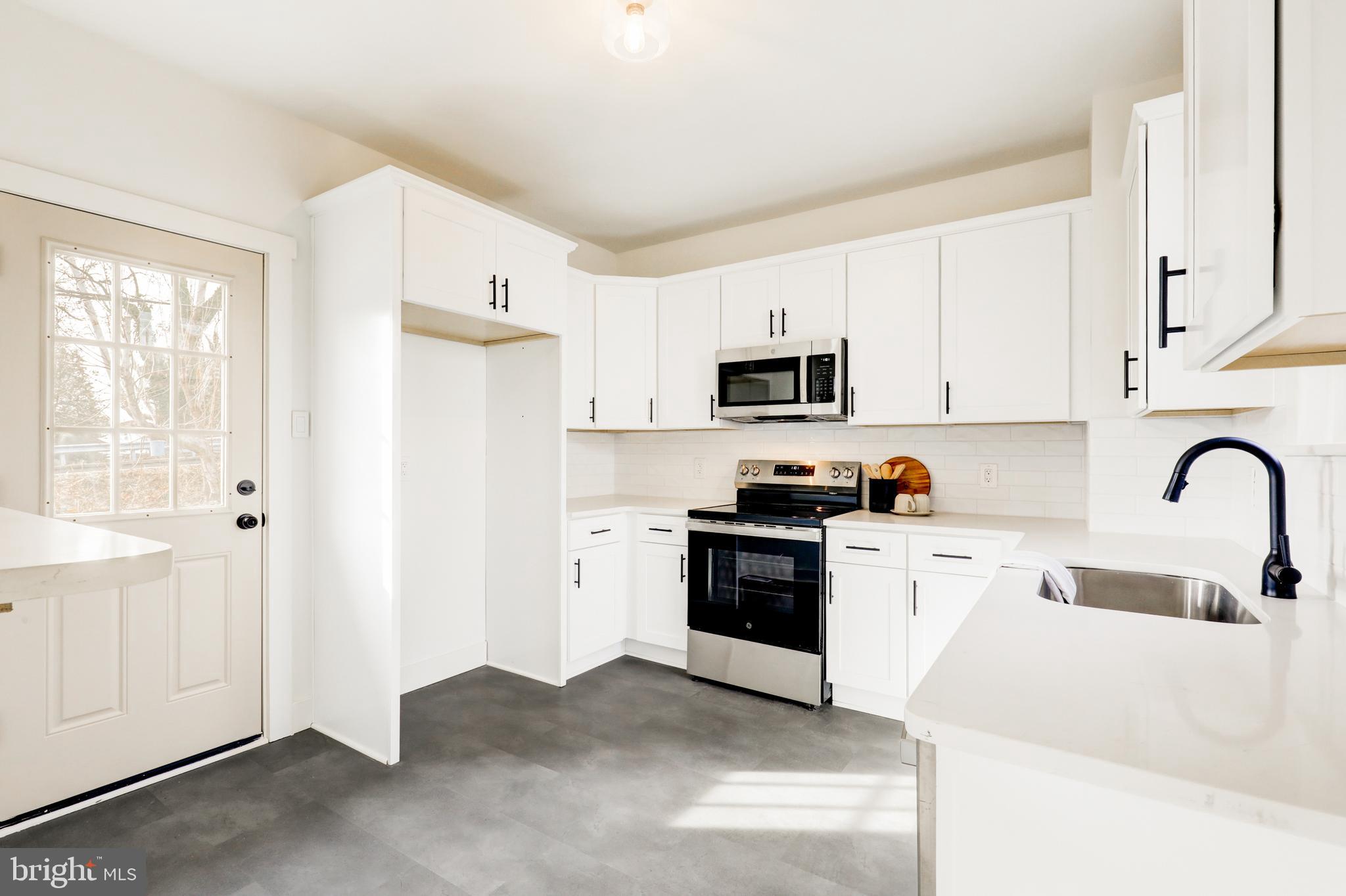 7301 North Radcliffe Street Bristol, PA 19007 - Photo 17 of 43 a kitchen with stainless steel appliances granite countertop white cabinets a sink a stove a refrigerator with white cabinets and a refrigerator
