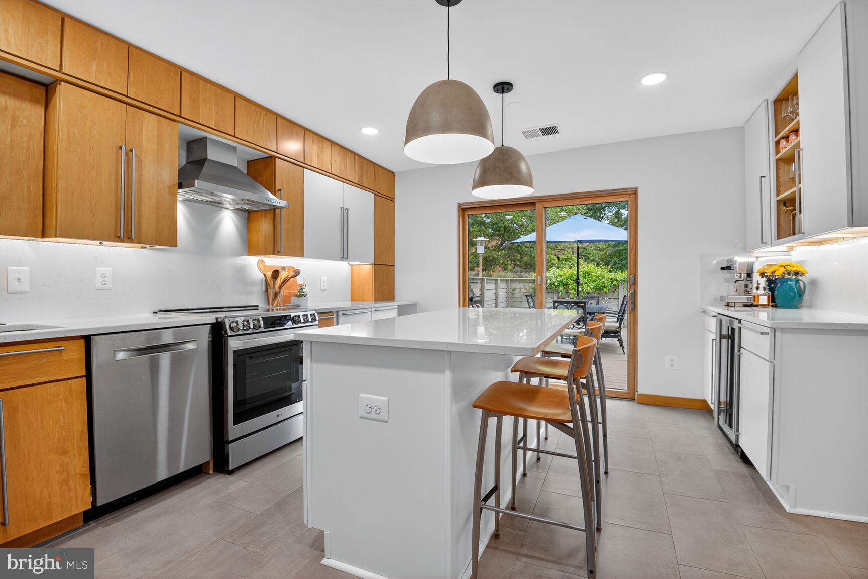 11775 Indian Ridge Road Reston, VA 20191 - Photo 4 of 29 a kitchen with stainless steel appliances granite countertop a stove top oven a sink a dining table and chairs with wooden floor