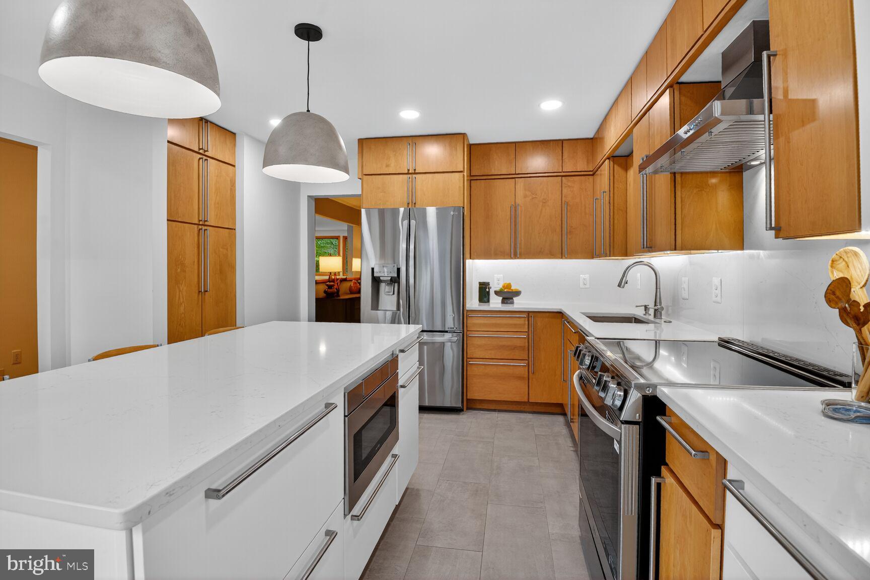 11775 Indian Ridge Road Reston, VA 20191 - Photo 7 of 29 a kitchen that has a lot of cabinets a sink and a wooden floor