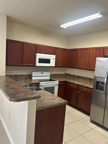 a kitchen with wooden cabinets a stove top oven a sink and dishwasher