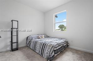 2781 Northwest 55th Way Lauderhill, FL 33313 - Photo 11 of 12 a bedroom with a bed and a window